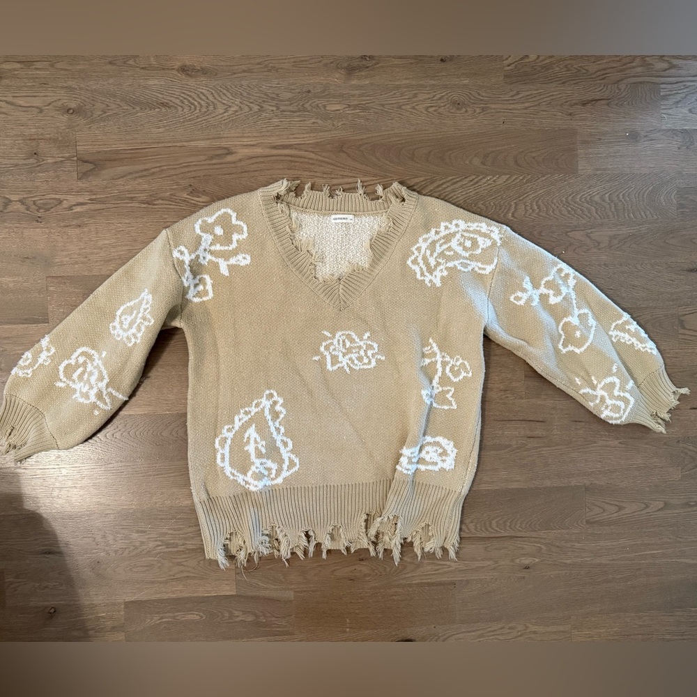 Frayed Beige Sweater with White Floral Patterns